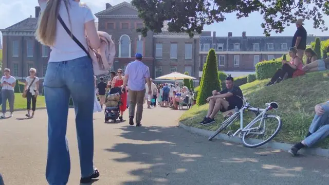 Visitors enjoy a sunny day at Kensington Palace Gardens, London.