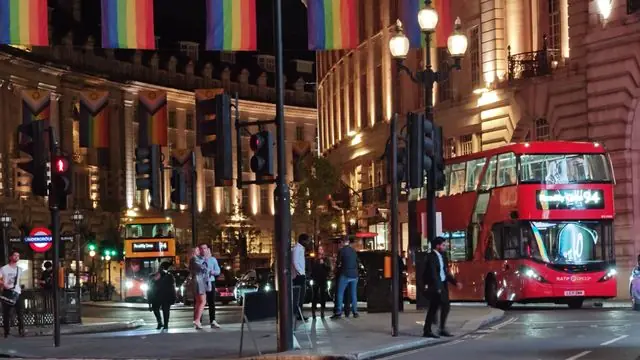 Regent Street, London, at night with buses and people.