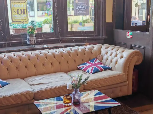 An English pub interior with a Union flag cushion on a sofa.