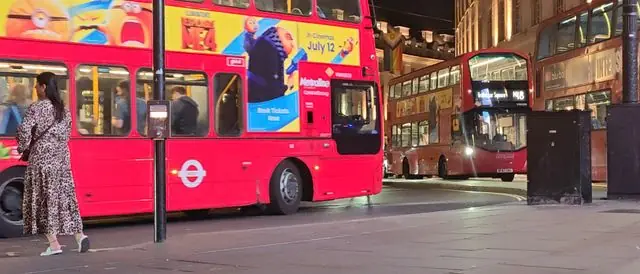 Regent Street, London, at night with red buses.