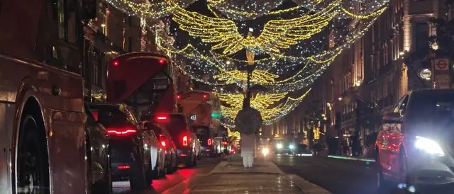 Christmas lights and traffic on a London street at night.