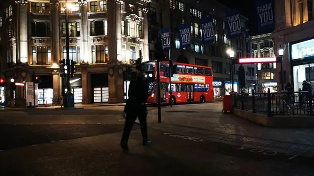 Oxford Circus at night, with red buses and city lights.