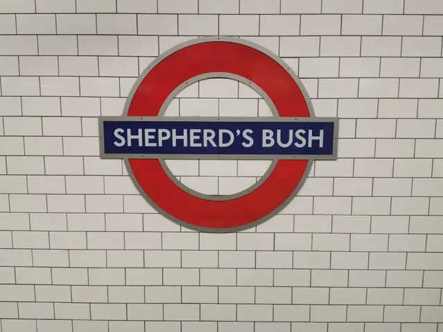 The Shepherd’s Bush Underground station sign on a tiled wall.